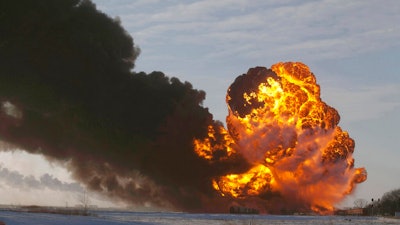 In this Dec. 30, 2013 file photo, a fireball goes up at the site of an oil train derailment near Casselton, N.D. The Trump administration is withdrawing a proposal for freight trains to have at least two crew members that was drafted in response to explosions of crude oil trains in the U.S. and Canada. Transportation officials said Thursday, May 23, 2019 that a review of accident data did not support the notion that having one crew member is less safe than a multi-person crew.