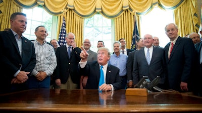 President Donald Trump, accompanied by Rep. Mike Conaway, R-Texas, fourth from left, Agriculture Secretary Sonny Perdue, fourth from right, and farmers and ranchers, speaks in the Oval Office of the White House, Thursday, May 23, 2019, in Washington.