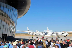 In this Oct. 17, 2011, file photo a crowd gathers outside Spaceport America for a dedication ceremony as Virgin Galactic's mothership WhiteKnightTwo sits on the tarmac near Upham, N.M. British billionaire Richard Branson is taking another concrete step toward offering rides into the close reaches of space for paying passengers. Branson announced Friday, May 10, 2019, that Virgin Galactic will immediately begin shifting operations from California to a spaceport and specialized runway in the New Mexico desert in final preparations for commercial flights. He says Virgin Galactic's development and testing program has advanced enough to make the move, which will continue through the summer.