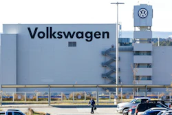 In this Dec. 4, 2015, file photo, a man walks through the employee parking lot at the Volkswagen plant in Chattanooga, Tenn. In a split decision, the National Labor Relations Board on Wednesday, May 22, 2019, has ruled in favor of Volkswagen in a setback for unionization efforts at its Chattanooga, Tennessee, plant. The NRLB has dismissed a petition for a union vote by the United Auto Workers based on a technicality. The union intends to refile immediately.