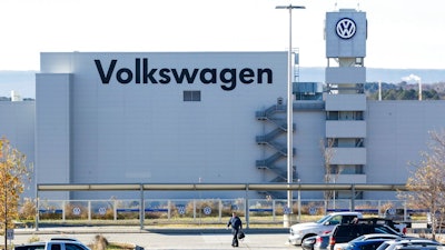 In this Dec. 4, 2015, file photo, a man walks through the employee parking lot at the Volkswagen plant in Chattanooga, Tenn. In a split decision, the National Labor Relations Board on Wednesday, May 22, 2019, has ruled in favor of Volkswagen in a setback for unionization efforts at its Chattanooga, Tennessee, plant. The NRLB has dismissed a petition for a union vote by the United Auto Workers based on a technicality. The union intends to refile immediately.