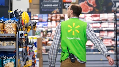 In this April 24, 2019, file photo a Walmart associate works at a Walmart Neighborhood Market in Levittown, N.Y. Walmart Inc. reports earnings on Thursday, May 16.