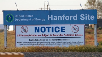 In this May 9, 2017 file photo, signs are posted by the Hanford Nuclear Reservation in Benton County, in Richland, Wash. The U.S. Department of Energy said Wednesday, Oct. 4, 2017 that workers at Hanford have started injecting grout into a partially collapsed tunnel that contains radioactive wastes left over from the production of nuclear weapons.