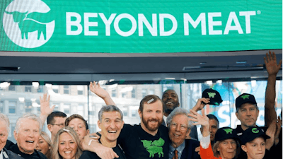 Ethan Brown, center, CEO of Beyond Meat, attends the Opening Bell ceremony with guests to celebrate the company's IPO at Nasdaq, Thursday, May 2, 2019 in New York. California-based Beyond Meat makes burgers and sausages out of pea protein and other ingredients.