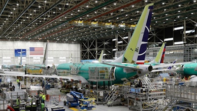 In this March 27, 2019, file photo people work on the Boeing 737 MAX 8 assembly line during a brief media tour in Boeing's 737 assembly facility in Renton, Wash. On Wednesday, May 1, the Institute for Supply Management, a trade group of purchasing managers, issues its index of manufacturing activity for April.