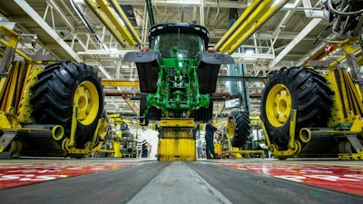 In this April 9, 2019, wheels are attach as workers assemble a tractor at John Deere's Waterloo, Iowa assembly plant. Deere & Co. reports earnings on Friday, May 17.