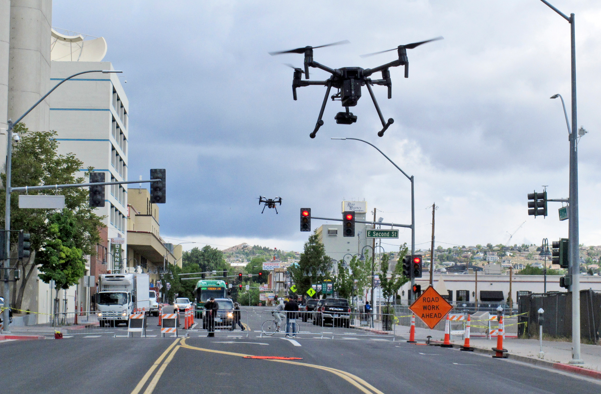 In this May 21, 2019 photo, two drones fly above Lake Street in downtown Reno, Nev., on, as part of a NASA simulation to test emerging technology that someday will be used to manage travel of hundreds of thousands of commercial, unmanned aerial vehicles (UAVs) delivering packages. It marked the first time such tests have been conducted in an urban setting.
