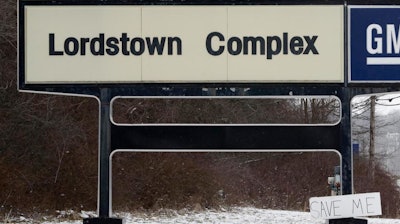 In this March 6, 2019, file photo, a 'Save Me' sign rests against the General Motors Lordstown Complex sign in Lordstown, Ohio. General Motors plans to sell its shuttered factory in Lordstown, to a company that builds electric trucks. President Donald Trump announced the deal Wednesday morning, May 8, 2019, on Twitter.