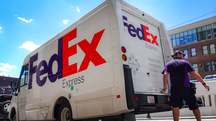 A FedEx delivery truck is loaded by an employee on the street, Tuesday, June 25, 2019, in downtown Cincinnati. FedEx Corp. (FDX) on Tuesday reported a fiscal fourth-quarter loss of $1.97 billion, after reporting a profit in the same period a year earlier.