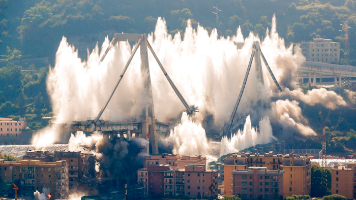 A cloud of dust rises as the remaining spans of the Morandi bridge are demolished in a planned expolosion, in Genoa, Italy, Friday, June 28, 2019. The spectacular planned explosion knocked down the remaining spans and supporting columns of the Italian bridge that collapsed last year, killing 43 people and some 3,500 people who live nearby had been evacuated as a precaution in the last hours; sirens sounded a final warning.