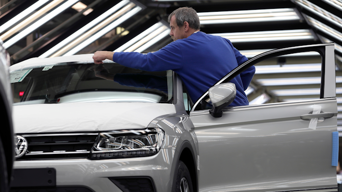 In this Thursday, March 8, 2018 photo an employee works on a Volkswagen car during a final quality control at the Volkswagen plant in Wolfsburg, Germany. Automaker Volkswagen is ruling out compulsory layoffs at its core brand’s German plants for the next 10 years even as it looks for cost cuts and adapts to increasing digitalization.