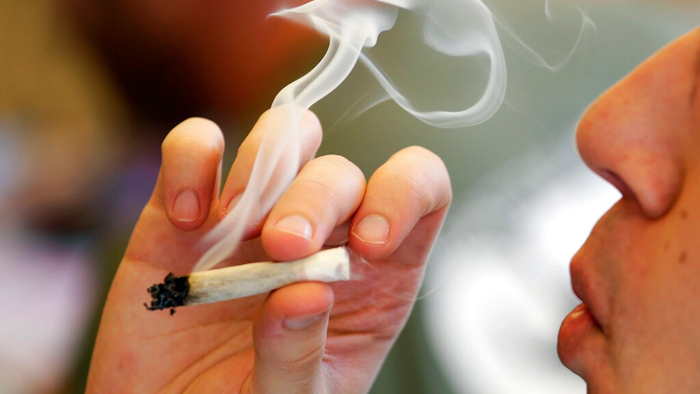 In this April 20, 2016, file photo, a man smokes a marijuana joint at a party celebrating weed in Seattle. A new federally funded study found, not surprisingly, that marijuana use in Washington state is up since pot became legal in 2014. The hard, or not-so-hard, evidence was in sewage samples.
