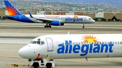 In this May 9, 2013, file photo, two Allegiant Air jets taxi at McCarran International Airport in Las Vegas. Federal safety regulators want to fine Allegiant Air more than $715,000, saying the discount airline failed to properly fix an engine that put out hotter-than-normal exhaust fumes. Allegiant says that it followed a procedure approved by the manufacturer and the government.