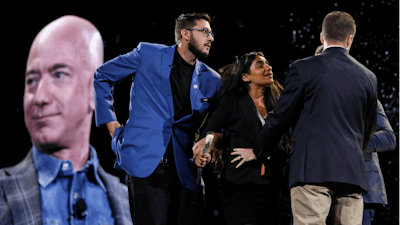 Security removes a protestor from the stage as Amazon CEO Jeff Bezos speaks at the the Amazon re:MARS convention in Las Vegas.