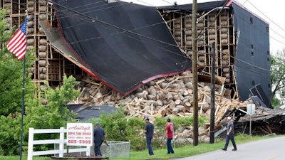 Workers from O.Z. Tyler Distillery look over Warehouse H, which collapsed during a thunderstorm shortly after midnight Monday, June 17, 2019 in Owensboro, Ky. Master Distiller Jacob Call says around 20,000 barrels are stored at the location and it appears that about 4,000 were affected.