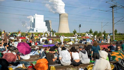 Numerous environmental activists block the tracks of the coal transport railway in Rommerskirchen, Germany, Saturday, June 22, 2019. The protests for more climate protection in the Rhineland continue. Many participants are expected for protests and actions at the Garzweiler opencast mine.