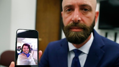 In this Wednesday, June 19, 2019 photo, Eric Ridenhour poses with a photo he took of his fiancee Kiersten Smith. Smith was killed in the June 9 crane collapse in downtown Dallas.