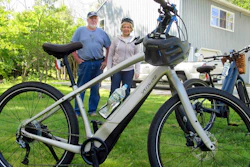 In this June 8, 2019 photo, Gordon and Janice Goodwin show their electric-assist bicycles outside their home in Bar Harbor, Maine. The bikes are banned on carriage roads and bicycle paths in nearby Acadia National Park.