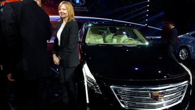 In this April 19, 2015, file photo General Motors CEO Mary Barra stands next to the Cadillac CT6 luxury sedan during a General Motors event ahead of the Auto Shanghai show in Shanghai, China. General Motors is adding 70,000 miles (113,000 kilometers) of roads across the U.S. and Canada to the area where its Cadillac Super Cruise semi-autonomous driving system can run, including some with cross traffic similar to those that have confused Tesla's Autopilot system.