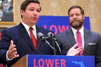 Florida Gov. Ron DeSantis speaks about the need to lower prescription costs by importing drugs from other countries, Tuesday, June 11, 2019, at the Eisenhower Recreation Center in The Villages, Fla. Listening at right is state Sen. Aaron Bean.