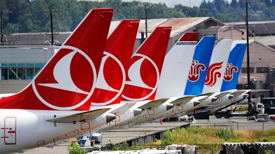 The tails of several of the dozens of grounded Boeing 737 MAX airplanes line the edge of a parking area adjacent to Boeing Field Thursday, June 27, 2019, in Seattle. A new software problem has been found in the troubled Boeing 737 Max that could push the plane's nose down automatically, and fixing the flaw is almost certain to further delay the plane's return to flying after two deadly crashes. Boeing said Wednesday, June 26, 2019, that the FAA 'identified an additional requirement' for software changes that the aircraft manufacturer has been working on for eight months, since shortly after the first crash.