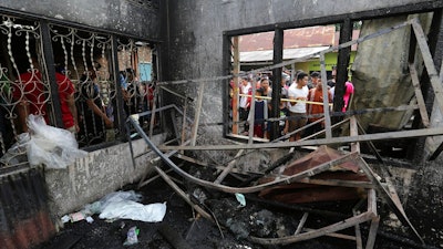 Residents examine the damage after a fire razed through a match factory in Langkat, North Sumatra, Indonesia, Friday, June 21, 2019. A number of people including children were killed in the fire that swept through a house that doubled as a match factory, a disaster official said Friday.