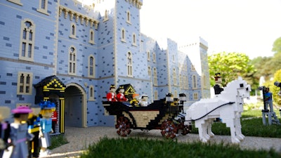 In this Friday, May 11, 2018 file photo, the newest attraction at Legoland in Windsor, England, shows a depiction of the wedding of Prince Harry and Meghan Markle outside Windsor Castle. A group of investors that includes the owners of toy maker Lego is buying Merlin Entertainment, a British company that operates theme parks like Legoland. Merlin said Friday June 28, 2019, it accepted the deal.