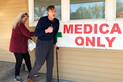 In this April 26, 2019, photo, medical marijuana cardholder Scott Donnelly, assisted by his wife and licensed caregiver, Vicki Poppen, leaves Western Oregon Dispensary in Sherwood, Ore., after buying medical marijuana to treat muscle spasms caused by his multiple sclerosis. Donnelly visits the medical-only dispensary once a week and relies on it for the cannabis that eases his tremors long enough that he can fall asleep. The dispensary is one of two medical-only shops left in Oregon.