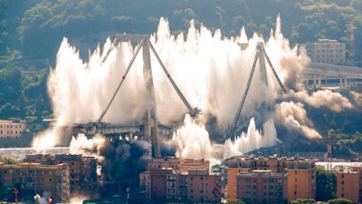 A cloud of dust rises as the remaining spans of the Morandi bridge are demolished in a planned expolosion, in Genoa, Italy, Friday, June 28, 2019. The spectacular planned explosion knocked down the remaining spans and supporting columns of the Italian bridge that collapsed last year, killing 43 people and some 3,500 people who live nearby had been evacuated as a precaution in the last hours; sirens sounded a final warning.