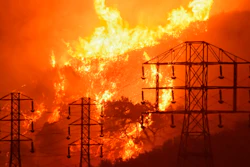 This file photo shows flames burning near power lines in Montecito, California during 2017 wildfires caused by PG&E equipment.