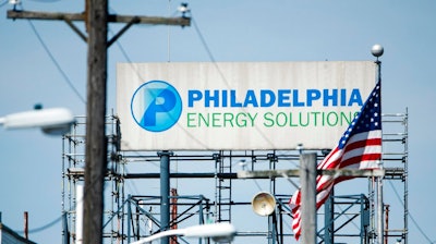 A sign for Philadelphia Energy Solutions stands at the refining complex in Philadelphia, Thursday, June 27, 2019. The largest oil refinery on the East Coast said Wednesday that it will close after a devastating fire last week that set off explosions and damaged equipment.