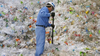 In this June 18, 2019, photo, a plastic recycling company worker sorts out plastic bottles collected for processing at Tokyo Petbottle Recycle Co., Ltd, in Tokyo. Japan has a plastic problem. Single bananas here are sometimes wrapped in plastic. So are individual pieces of vegetables, fruit, pastries, pens and cosmetics. Plastic-wrapped plastic spoons come with every ice cream cup. But as world leaders descend on Osaka for the two-day G20 Summit that starts Friday, June 28, Japan has ambitions to become a world leader in reducing plastic waste.