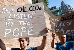 Activists hold up signs outside the Vatican as Pope Francis meets with oil executives, Friday, June 14, 2019. The meeting marked the second year that Francis has invited oil and financial sector executives to the Vatican to impress upon them his concern that preserving God’s creation is one of the fundamental challenges facing humankind today.