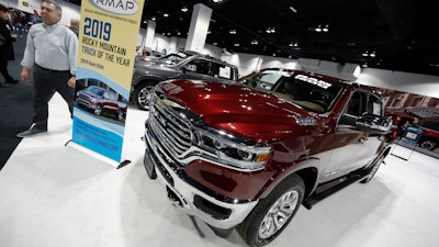 In this March 28, 2019 file photo buyers look over a 2019 Ram pickup truck on display at the auto show in Denver.