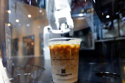 In this May 22, 2019, photo, a cup of coffee is placed by a robot named b:eat for a customer at a cafe in Seoul, South Korea. South Korea expands adoption of unmanned technology in businesses to meet the changing patterns of consumers who increasingly favor shopping or enjoying services with minimized human interactions and to reduce burdens of high labor costs.