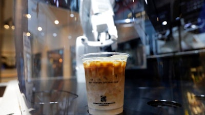 In this May 22, 2019, photo, a cup of coffee is placed by a robot named b:eat for a customer at a cafe in Seoul, South Korea. South Korea expands adoption of unmanned technology in businesses to meet the changing patterns of consumers who increasingly favor shopping or enjoying services with minimized human interactions and to reduce burdens of high labor costs.