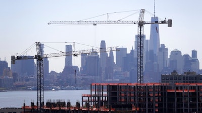 In this April 23, 2019, file photo building cranes are seen at the construction site of a condominium complex with the Lower Manhattan skyline seen in the background in Weehawken, N.J. The Federal Reserve releases its latest 'Beige Book' survey of economic conditions on Wednesday, June 5. The Beige Book is based on anecdotal reports from businesses and will be considered along with other data when Fed policymakers meet next.