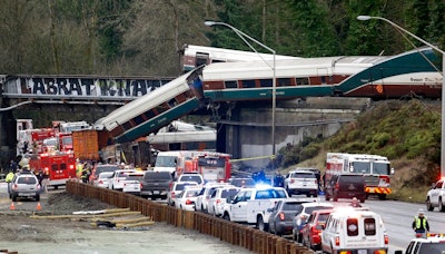 In this Dec. 18, 2017, file photo, cars from an Amtrak train lay spilled onto Interstate 5 below as some remain on the tracks above in DuPont, Wash. The National Transportation Safety Board has published its final report Monday, June 24, 2019, on a deadly Amtrak derailment in Washington state in 2017, with the agency's vice chairman blasting what he described as a 'Titanic-like complacency' among those charged with ensuring train operations are safe. The train was on its first paid passenger run on a new route from Tacoma to Portland, Oregon, when it plunged onto Interstate 5, killing three people and injuring dozens.