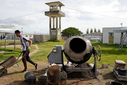 In this May 9, 2019 photo, an inmate works making concrete blocks, at a factory run by inmate Rolando Bustamante, at the Punta de Rieles prison in Montevideo, Uruguay. Bustamante's factory is one of dozens of inmate businesses in the prison, which has been transformed into an unusual experiment. Inmates form businesses, work for one another and offer products both to the world within the walls and to that without.