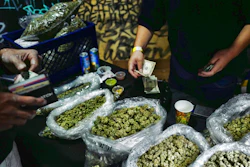 In this April 15, 2019, file photo, a vendor makes change for a marijuana customer at Rev-Up a cannabis marketplace in Los Angeles. An alliance of large cannabis businesses in the growing global marketplace has a message for the public: We're good corporate citizens. The 45-member Global Cannabis Partnership that includes Canopy Growth Corp. and other major companies issued guidelines Tuesday, June 18, 2019, aimed at minimizing greenhouse gas emissions and promoting ethical conduct and responsible pot use.