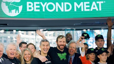 In this May 2, 2019, file photo Ethan Brown, center, CEO of Beyond Meat, attends the Opening Bell ceremony with guests to celebrate the company's IPO at Nasdaq in New York. Plant-based meat maker Beyond Meat beat Wall Street’s expectations in its first earnings report since its IPO last month. The El Segundo, California-based company lost $6.6 million, or 95 cents per share, in the first quarter, up slightly from a 98-cent loss in the same period a year ago.