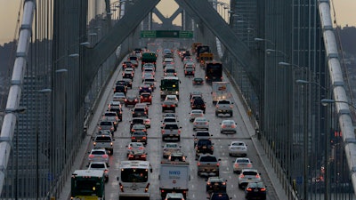 In this Dec. 10, 2015, file photo, vehicles make their way westbound on Interstate 80 across the San Francisco-Oakland Bay Bridge as seen from Treasure Island in San Francisco. Major automakers are urging the Trump administration and California to go back to the negotiating table over vehicle mileage standards to prevent a legal battle. The companies sent letters Thursday, June 6, 2019, to President Donald Trump and California Gov. Gavin Newsom saying a failure to reach agreement would create instability in the auto market.