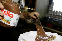 In this June 18 2010 file photo,a bartender spreads Nutella on a crepe in a creperie in Rome. French workers frustrated over salary negotiations are blocking the world's biggest Nutella factory. Tensions are mounting at the site in Villers-Ecalles in Normandy, where activists from the Workers' Force union have been blocking trucks from entering or leaving the factory for a week.