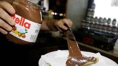 In this June 18 2010 file photo,a bartender spreads Nutella on a crepe in a creperie in Rome. French workers frustrated over salary negotiations are blocking the world's biggest Nutella factory. Tensions are mounting at the site in Villers-Ecalles in Normandy, where activists from the Workers' Force union have been blocking trucks from entering or leaving the factory for a week.