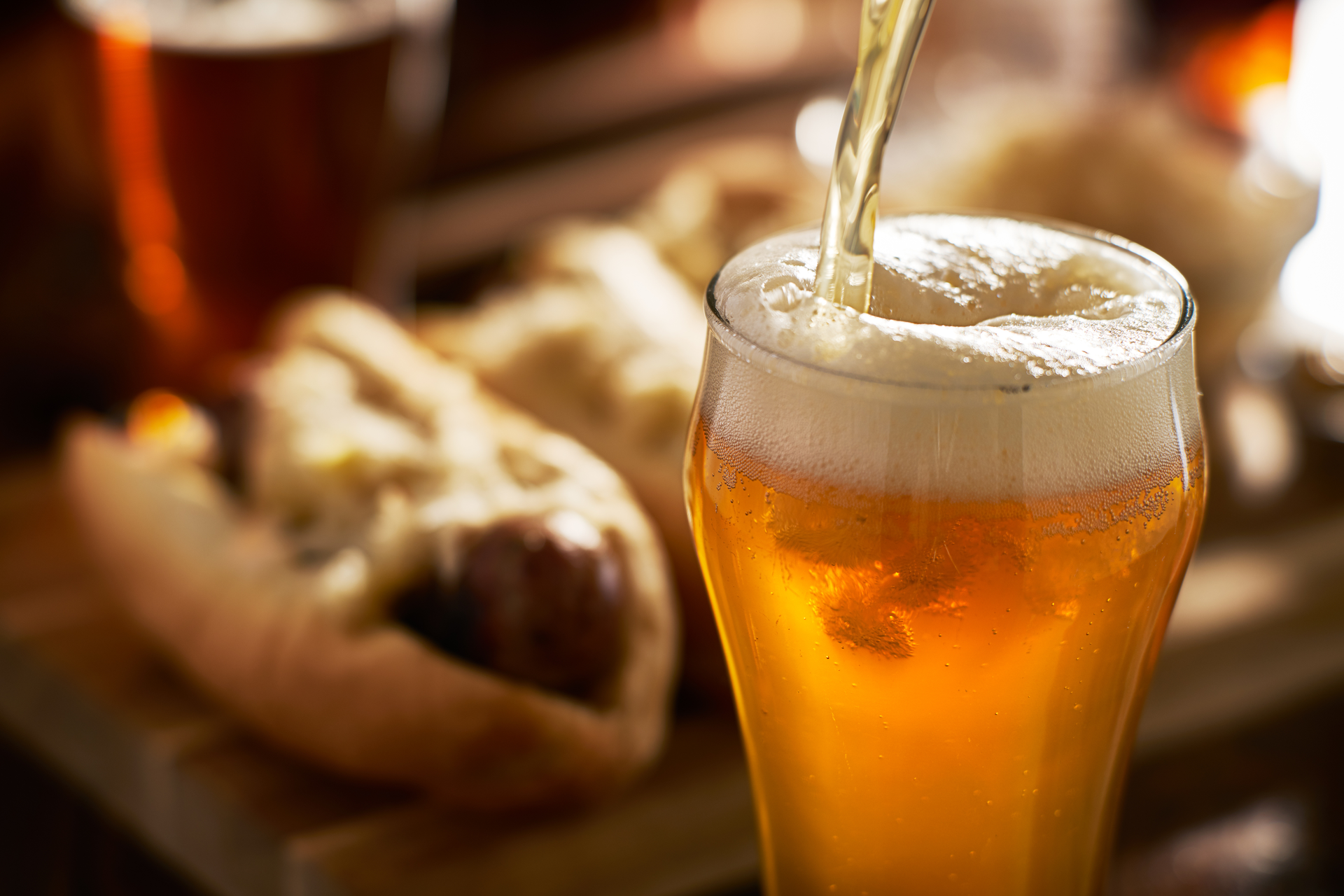 Pouring Amber Beer Into Mug With Bratwursts In Background 843389516 3867x2579