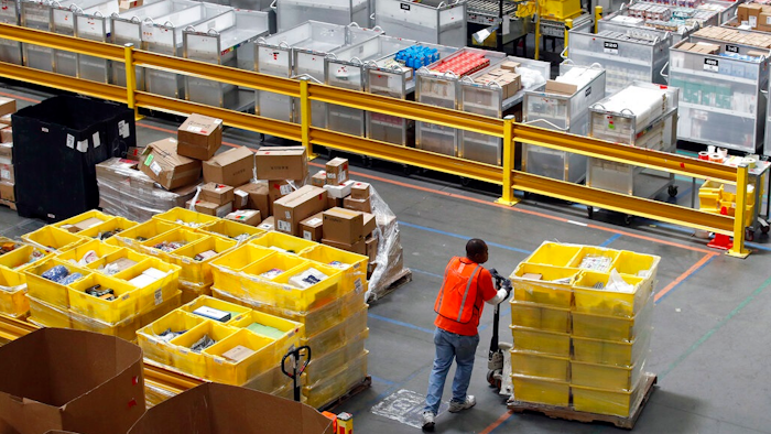 In this Aug. 3, 2017, file photo, a worker pushes bins at an Amazon fulfillment center in Baltimore. Amazon will spend more than $700 million to provide additional training to about one-third of its U.S. workforce.