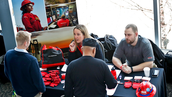 Recruiters talk to prospective workers at a job fair.