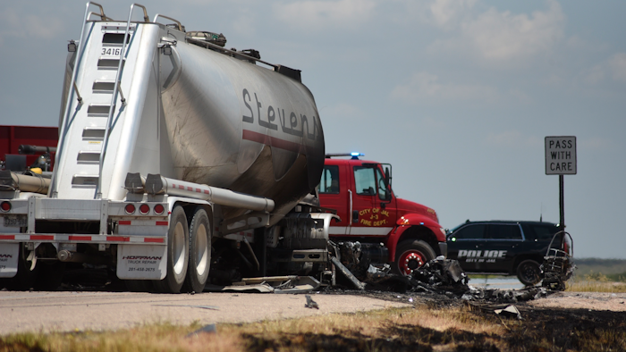 Grass along New Mexico State Route 128 near Jal shows burn marks following a fatal head-on crash. Authorities say four oilfield workers traveling in a pickup truck and the driver of a big rig were pronounced dead at the scene.