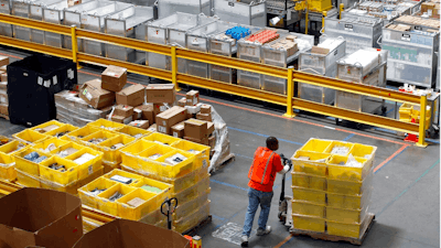 In this Aug. 3, 2017, file photo, a worker pushes bins at an Amazon fulfillment center in Baltimore. Amazon will spend more than $700 million to provide additional training to about one-third of its U.S. workforce.