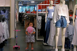 A child plays with a balloon at a clothing store having a promotion sale in Beijing, Monday, July 15, 2019. China's economic growth sank to its lowest level in at least 26 years in the quarter ending in June, adding to pressure on Chinese leaders as they fight a tariff war with Washington.